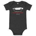 Tesla inspired apparel. Cybertruck. Apocalypse Near You image centered on baby onesie.